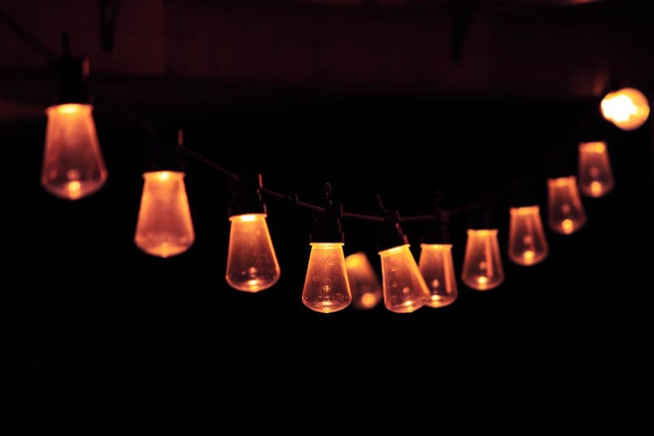 Warm festoon string lights glowing against a dark night sky