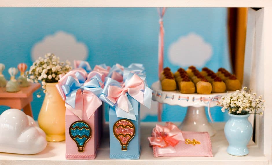 Pink and blue gift boxes on a baby shower favour table