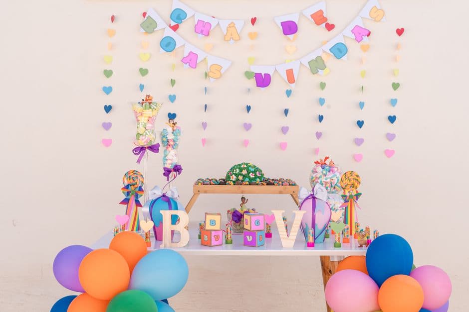 A pastel-decorated baby shower table with a grazing spread