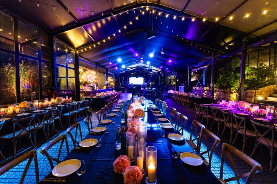 An event marquee set with long banquet tables for a corporate dinner