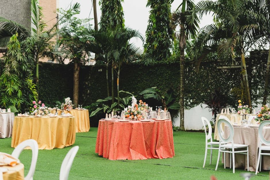 Round tables with floral centrepieces set for an outdoor garden party