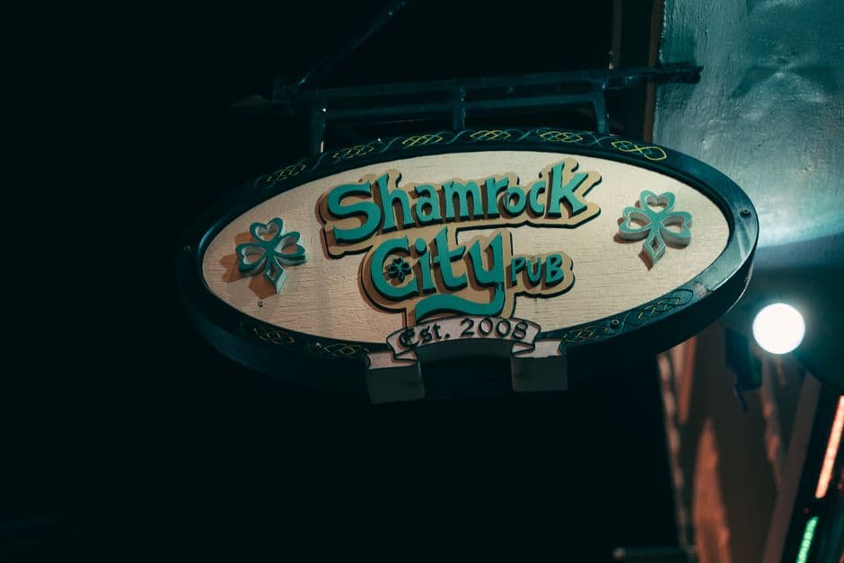 A glowing pub signboard at night, the kind of local that hosts a fundraising trivia night