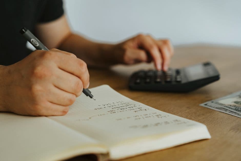 A calculator, notebook and pen laid out for budgeting