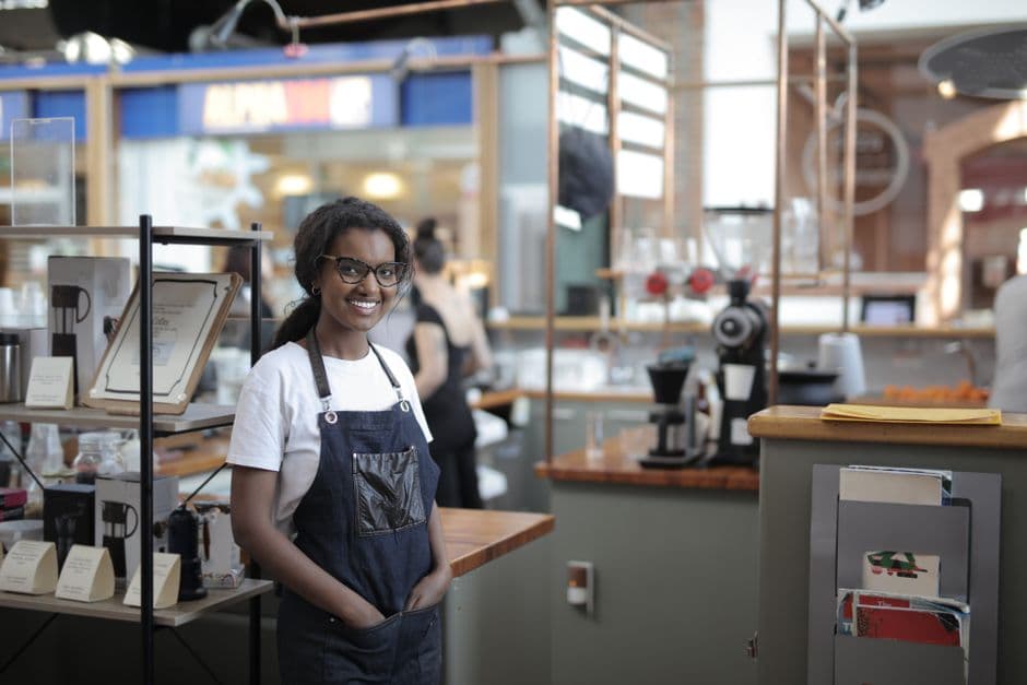 A local cafe owner behind the counter, the kind of small in-kind sponsor