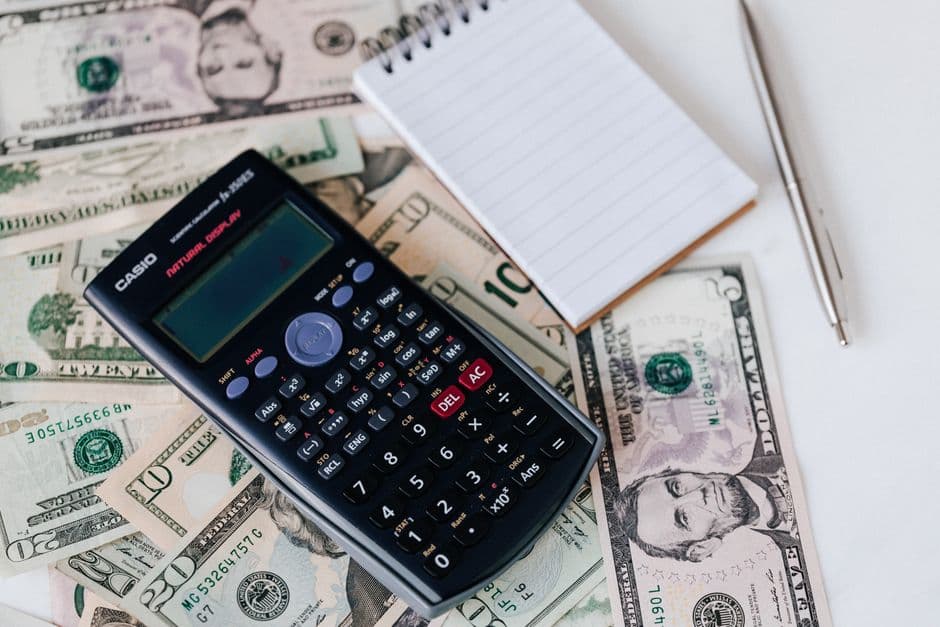 Comparing booking fees on a calculator and a notepad