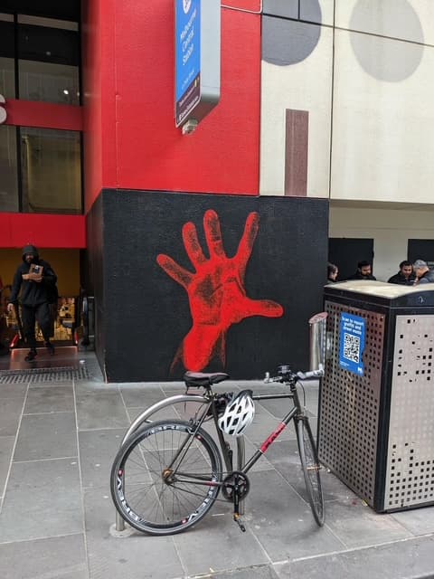 The matching System Of A Down red-hand mural on La Trobe Street in Melbourne