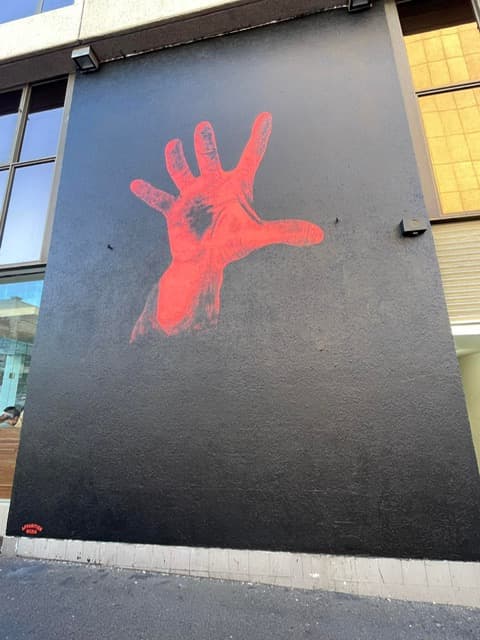 The System Of A Down red-hand mural on the corner of William and Crown Streets in Sydney