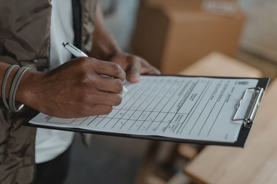 An organiser holding a run sheet on a clipboard backstage before an event