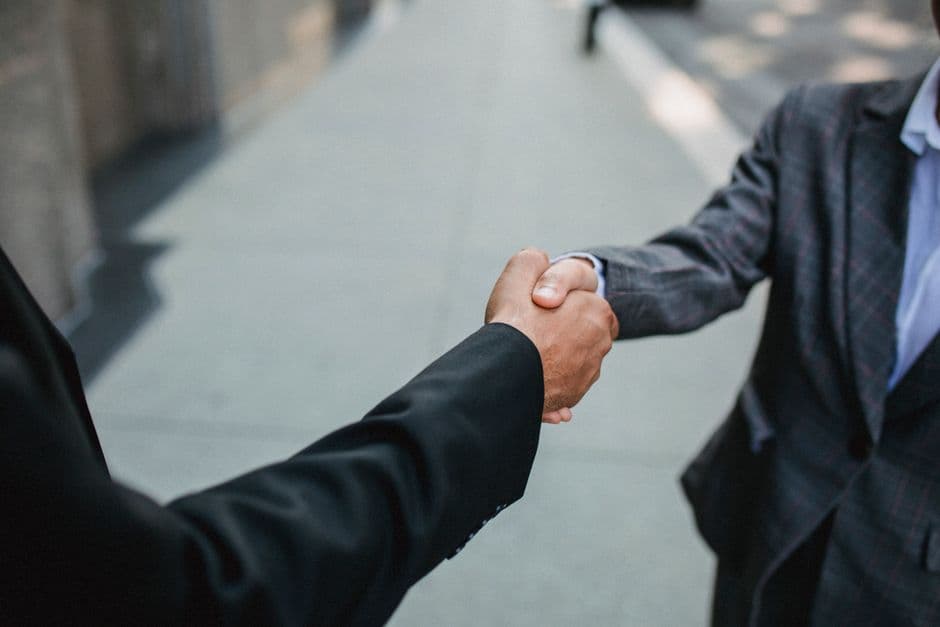 Two people shaking hands over an event sponsorship deal