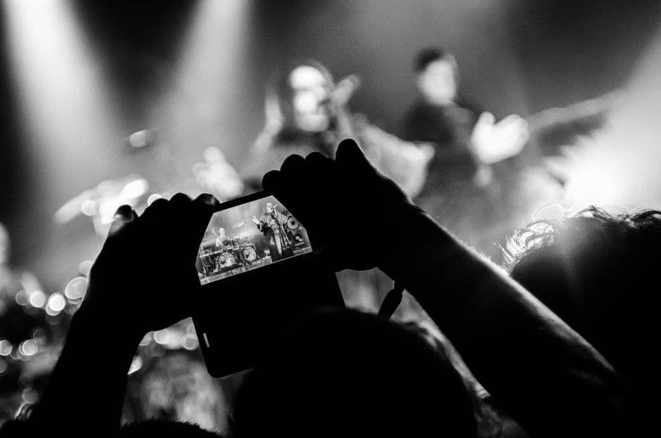A crowd at an event holding up phones